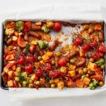 Traybake met zoete aardappel, chipolata & harissa